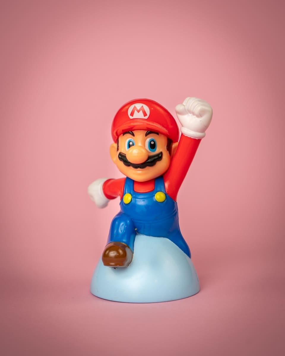 Photo by Mika Baumeister a toy figure of mario on top of a blue object
